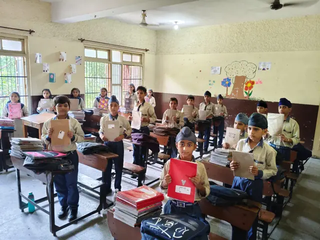 Pupils with books and learning materials in a classroom