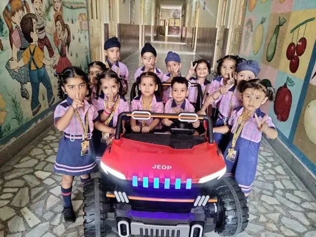 Young pupils gathered around a model car